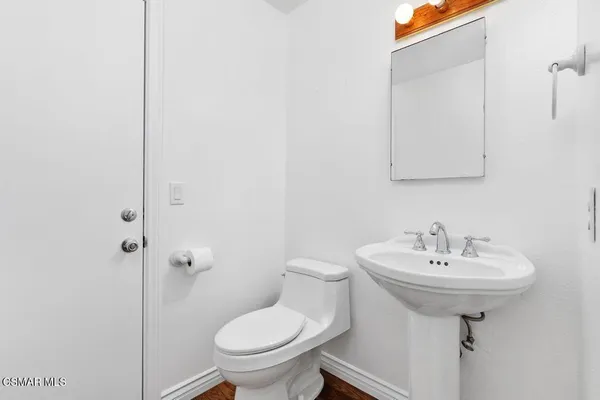 a bathroom with a sink toilet and a mirror