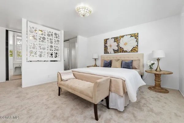 a bedroom with a bed and a painting on the wall