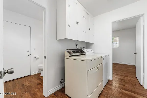 a utility room with cabinets washer and dryer