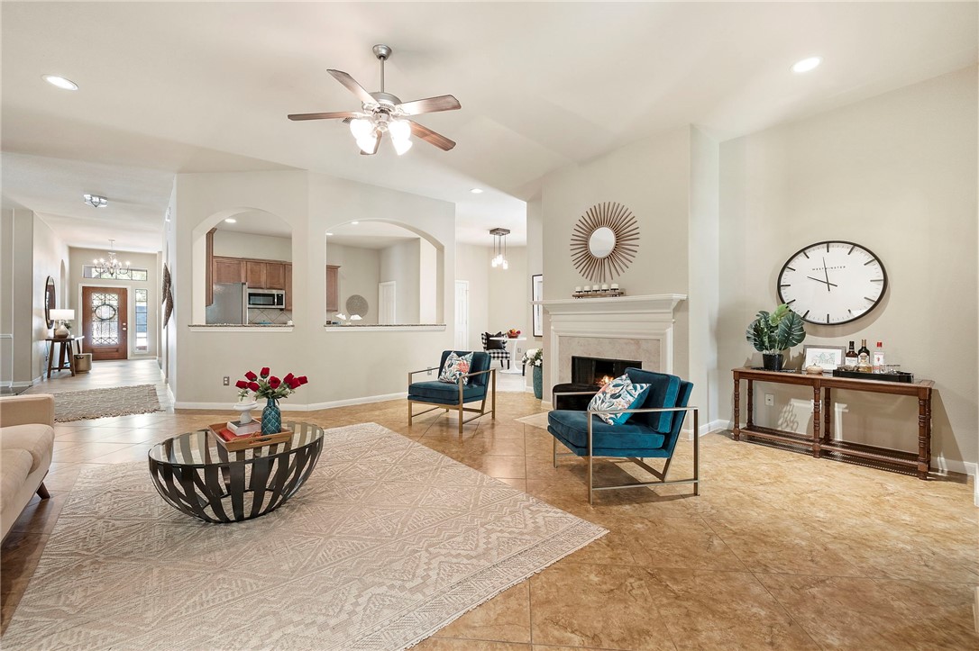 a living room with furniture a fireplace and a chandelier