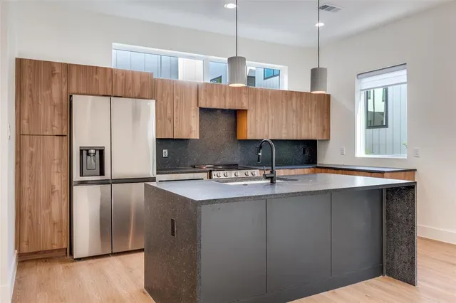 a kitchen with kitchen island granite countertop a sink a center island and cabinets