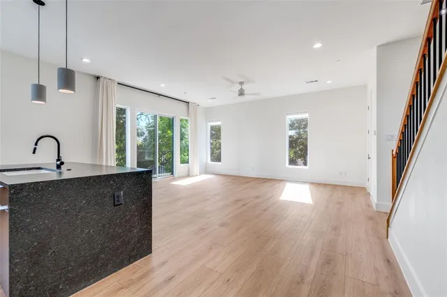 a view of a kitchen with a sink and dishwasher with wooden floor
