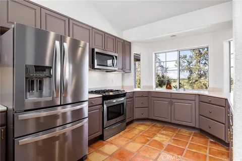 a kitchen with granite countertop stainless steel appliances a stove refrigerator and microwave
