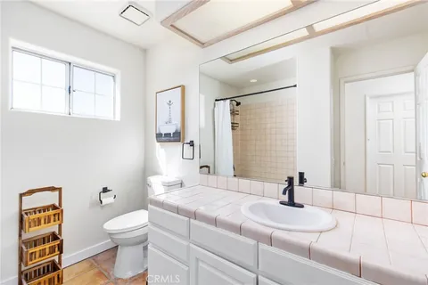 a bathroom with a granite countertop sink mirror vanity and toilet