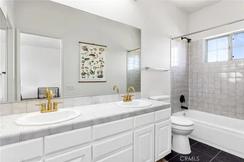a bathroom with a double vanity sink toilet and shower
