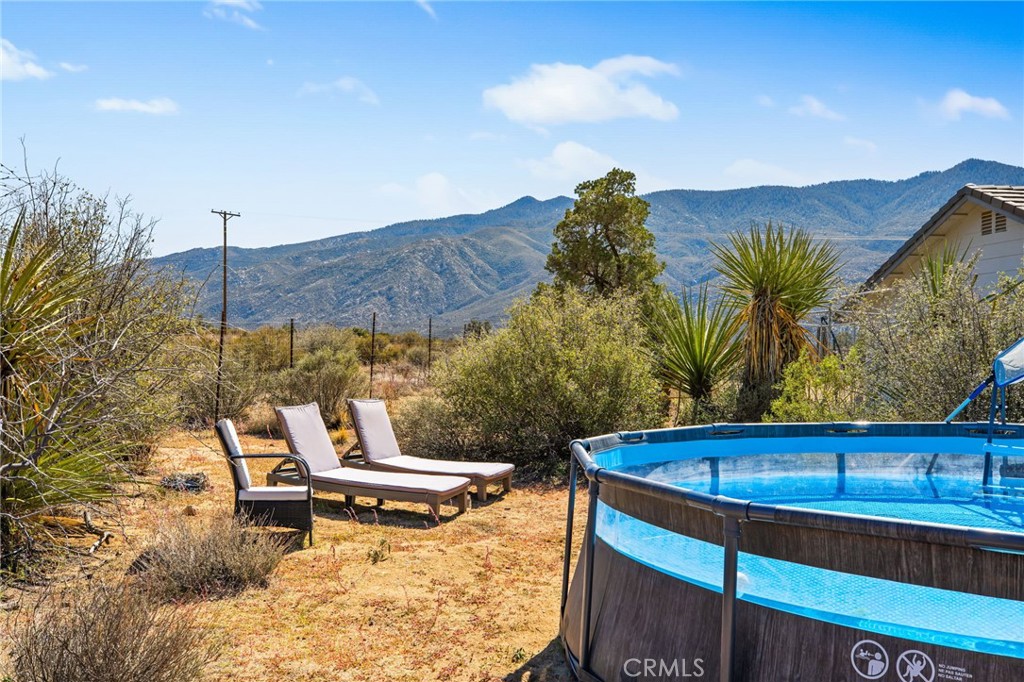 69945 Pinesmoke Road Mountain Center, CA 92561 - Photo 22 of 25 a blue swimming pool with a bench and some trees