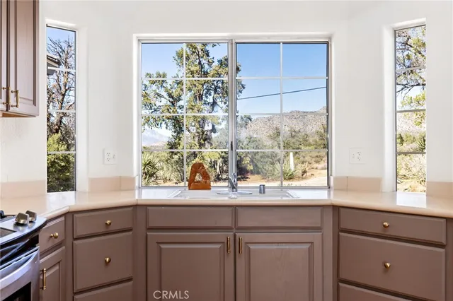 a sink with a window and cabinets