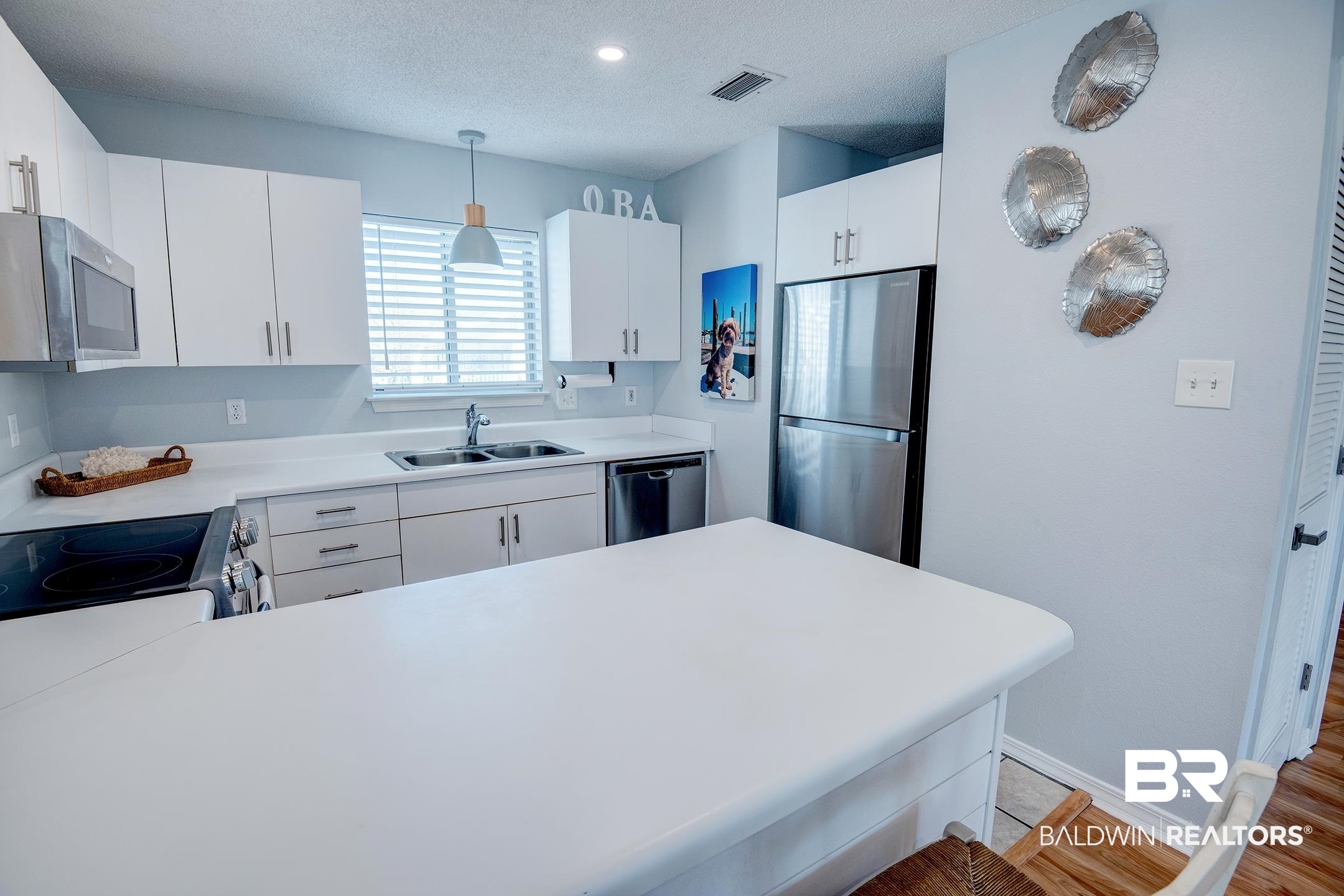 25957 Canal Road, Unit 206 Orange Beach, AL 36561 - Photo 9 of 30 Kitchen with a textured ceiling, light countertops, appliances with stainless steel finishes, and a sink
