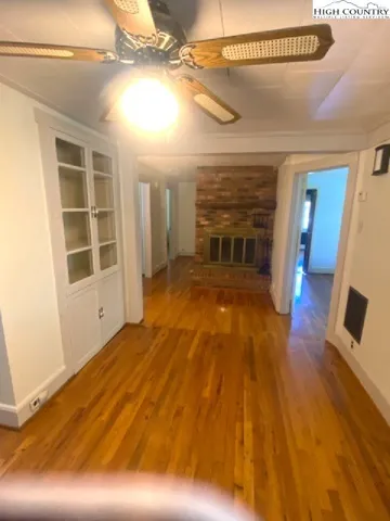 a view of a living room with wooden floor and ceiling fan
