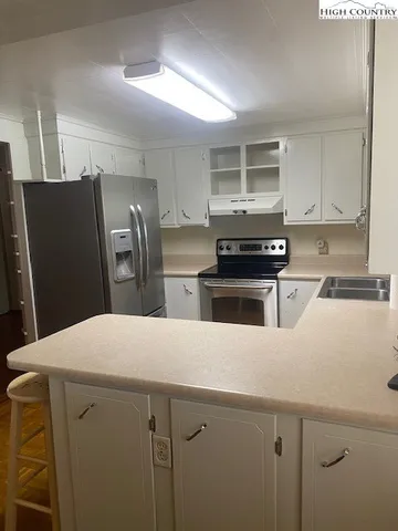 a kitchen with stainless steel appliances wooden cabinets and a refrigerator