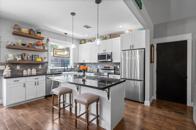 a kitchen with refrigerator cabinets and wooden floor