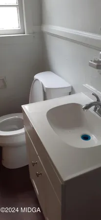 a bathroom with a sink toilet and window