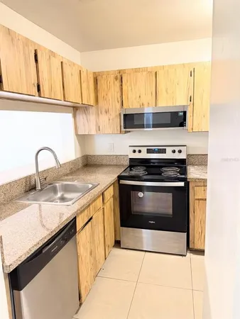 a kitchen with a stove a sink and a microwave