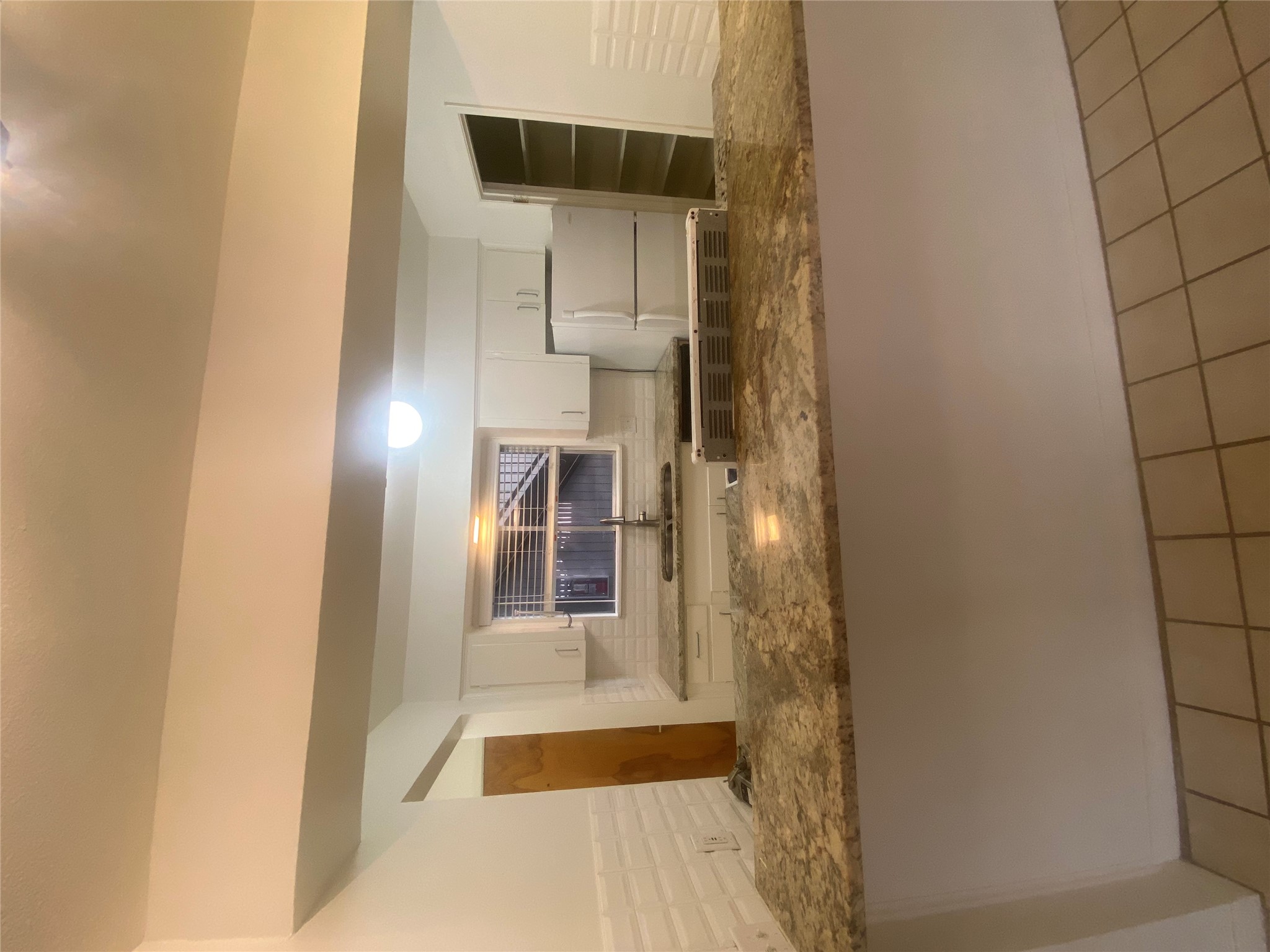 2208 Enfield Road, Unit 10500 Austin, TX 78703 - Photo 2 of 7 Kitchen featuring white cabinets, a peninsula, backsplash, freestanding refrigerator, and light tile patterned flooring