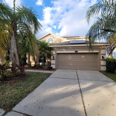 a view of a house with a yard and palm trees
