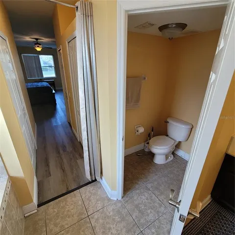 a view of a hallway to room with wooden floor and stairs
