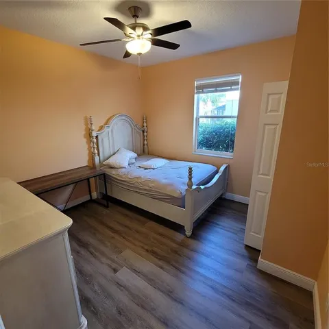 a bedroom with a bed and a ceiling fan