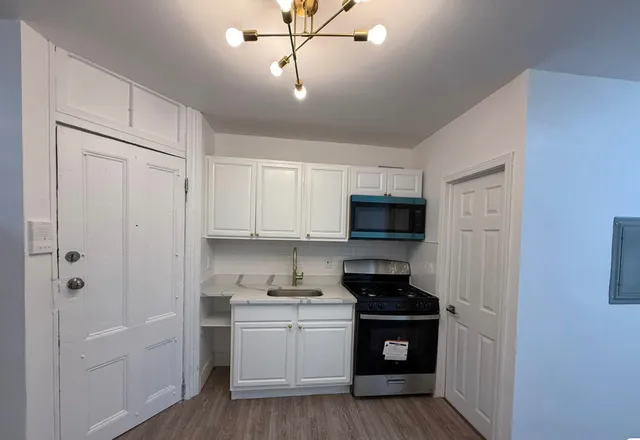a kitchen with a refrigerator stove and white cabinets