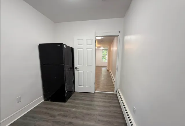 a view of a hallway with wooden floor and cabinets