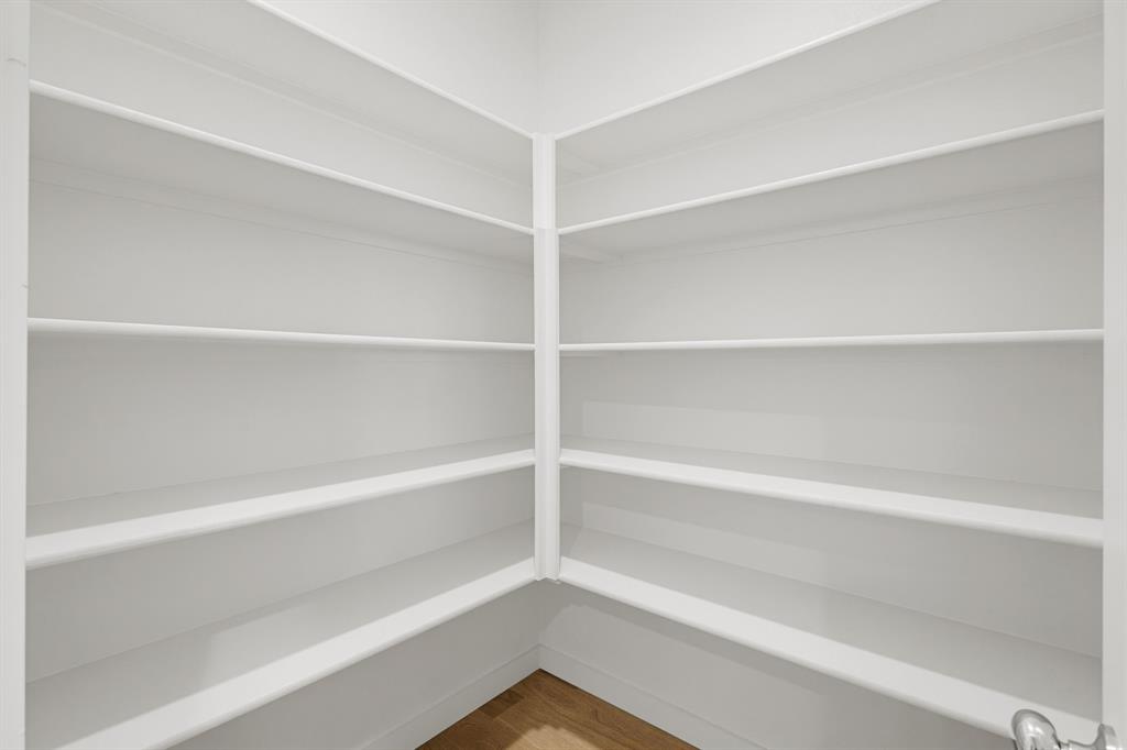 2108 Mossfield Lane Forney, TX 75126 - Photo 5 of 28 Walk-in pantry featuring white shelving, wood-finish flooring, and ample storage capacity