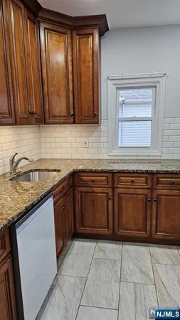 a kitchen with granite countertop a sink and cabinets