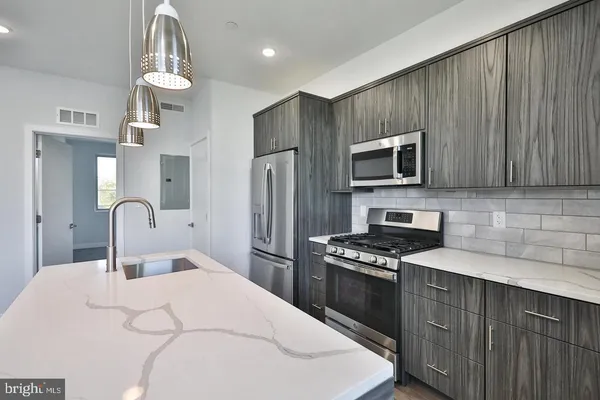 a kitchen with a sink a microwave and refrigerator