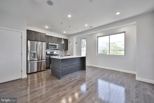 a kitchen with stainless steel appliances a refrigerator and a stove top oven