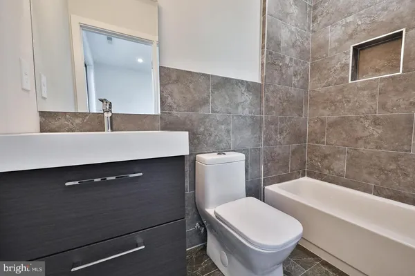 a bathroom with a sink a toilet and a mirror