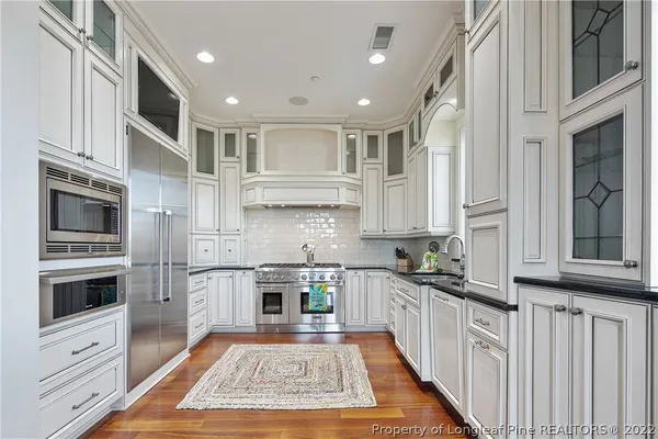 a kitchen with stainless steel appliances granite countertop a stove a sink and a microwave