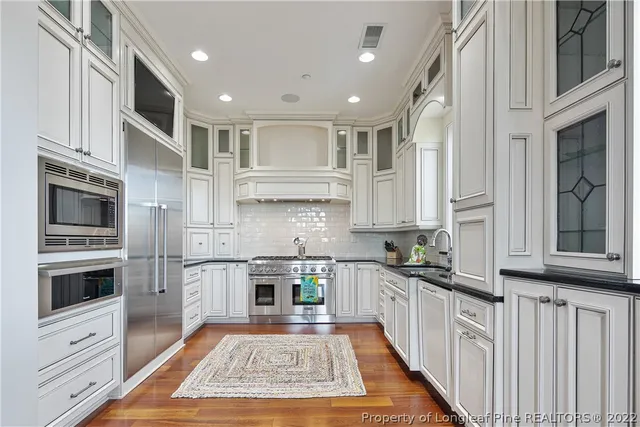 a kitchen with stainless steel appliances granite countertop a stove a sink and a microwave