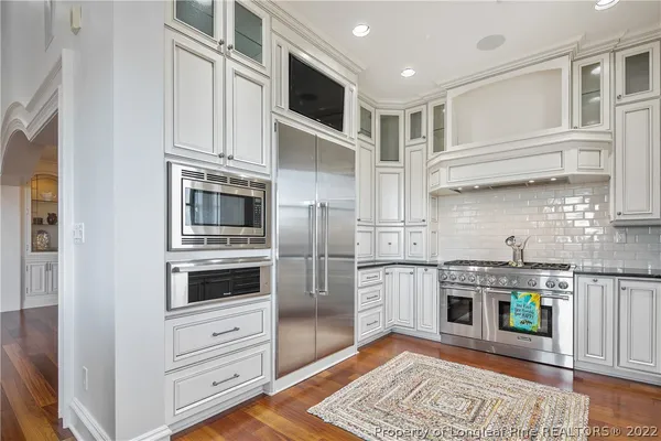 a kitchen with stainless steel appliances granite countertop a refrigerator and a stove top oven