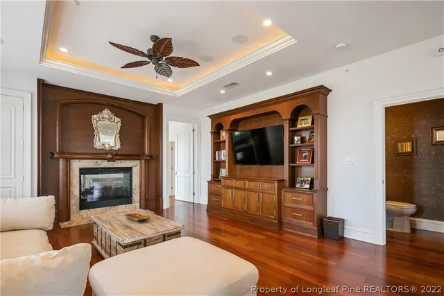a living room with furniture a fireplace and wooden floor