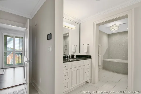 a bathroom with a granite countertop sink mirror and a bathtub