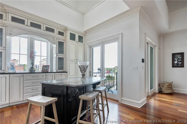 a kitchen with stainless steel appliances granite countertop a table chairs sink and cabinets