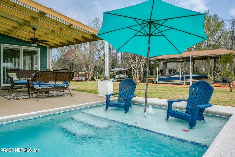 6433 River Point Drive Fleming Island, FL 32003 - Photo 45 of 71 a view of a swimming pool with a table and chairs under an umbrella
