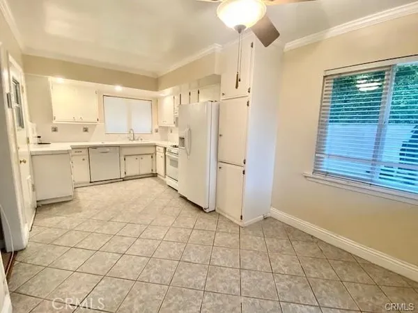 a large white kitchen with cabinets