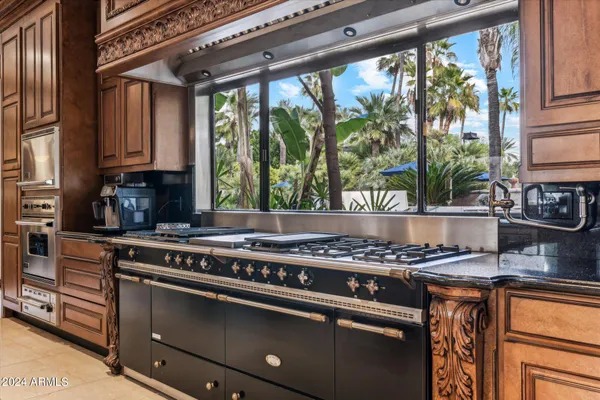 a large white kitchen with a stove a refrigerator a sink and dishwasher next to a window