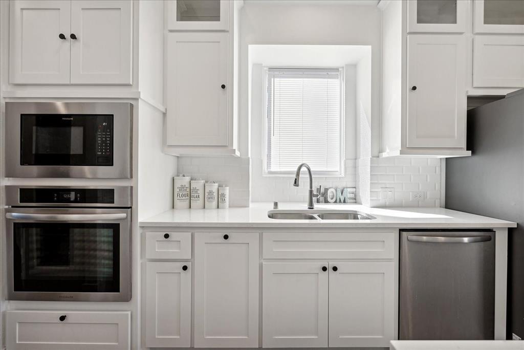 1710 Highwood Road Forney, TX 75126 - Photo 9 of 25 Modern kitchen featuring white shaker cabinetry, stainless steel appliances, a double basin sink, and white subway tile backsplash