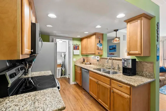 a kitchen with stainless steel appliances granite countertop a sink stove and refrigerator