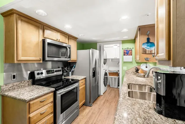a kitchen with stainless steel appliances kitchen island granite countertop a stove refrigerator and microwave