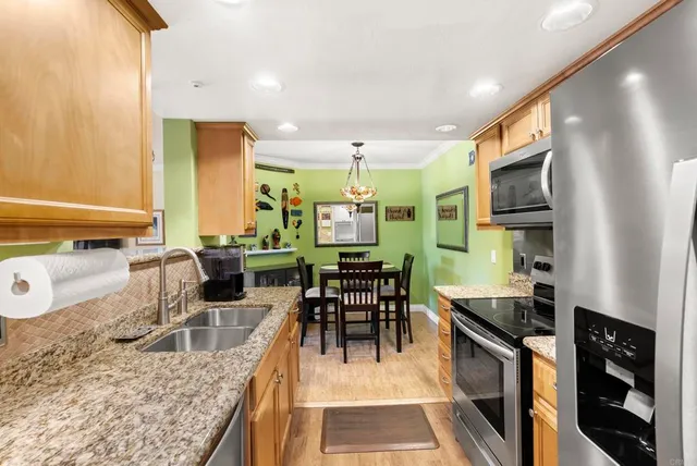 a kitchen with stainless steel appliances granite countertop sink stove top oven and cabinets