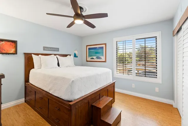 a bedroom with a bed and a dresser next to a window