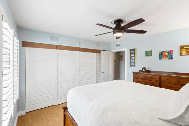 a bedroom with a large bed and a ceiling fan