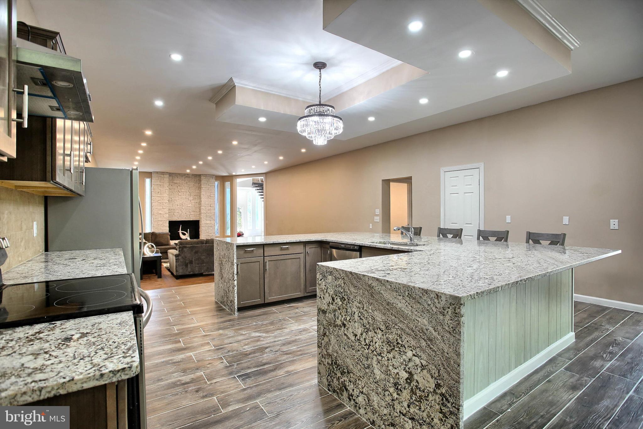 1813 Holly Drive Harrisburg, PA 17110 - Photo 30 of 61 a kitchen with stainless steel appliances granite countertop a sink a stove top oven a counter space and living room view
