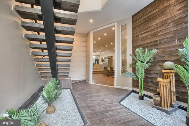 a view of a hallway with wooden floor and glass top table