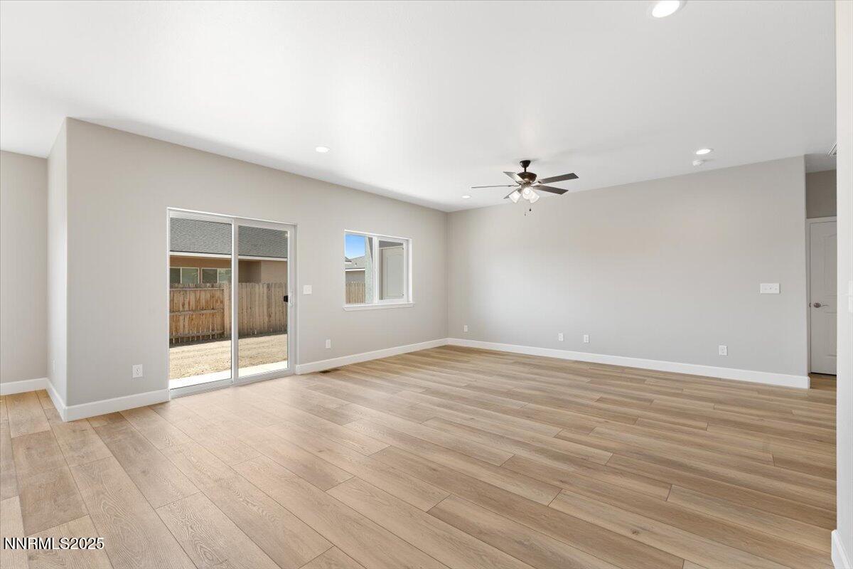 815 Great Basin Lane Fallon, NV 89406 - Photo 11 of 49 a view of an empty room with a window and wooden floor