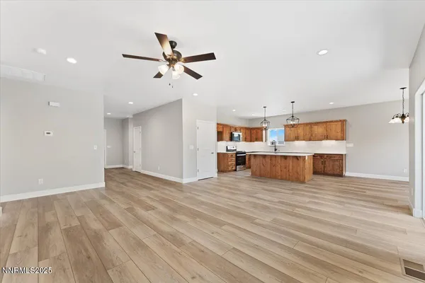 a kitchen with stainless steel appliances granite countertop a sink a stove and a wooden floors