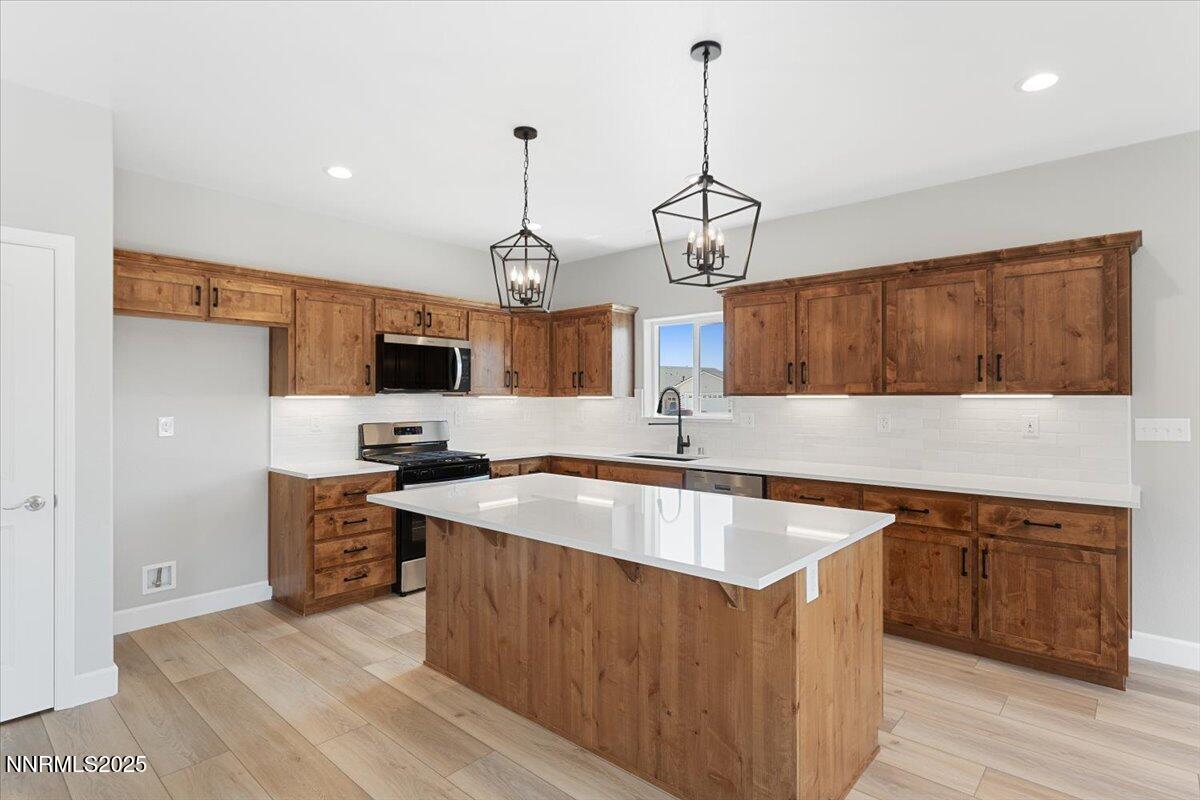 815 Great Basin Lane Fallon, NV 89406 - Photo 15 of 49 a kitchen with stainless steel appliances granite countertop a sink a stove and a wooden floors