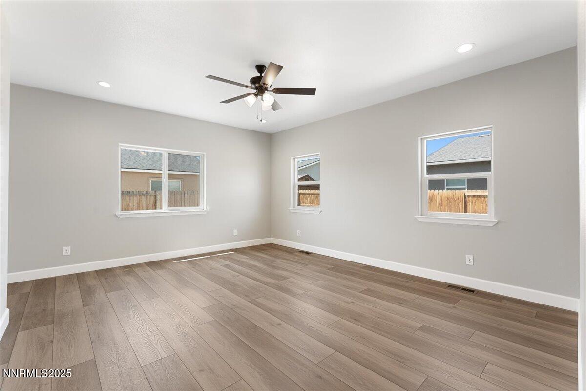 815 Great Basin Lane Fallon, NV 89406 - Photo 26 of 49 a view of an empty room with a window and wooden floor