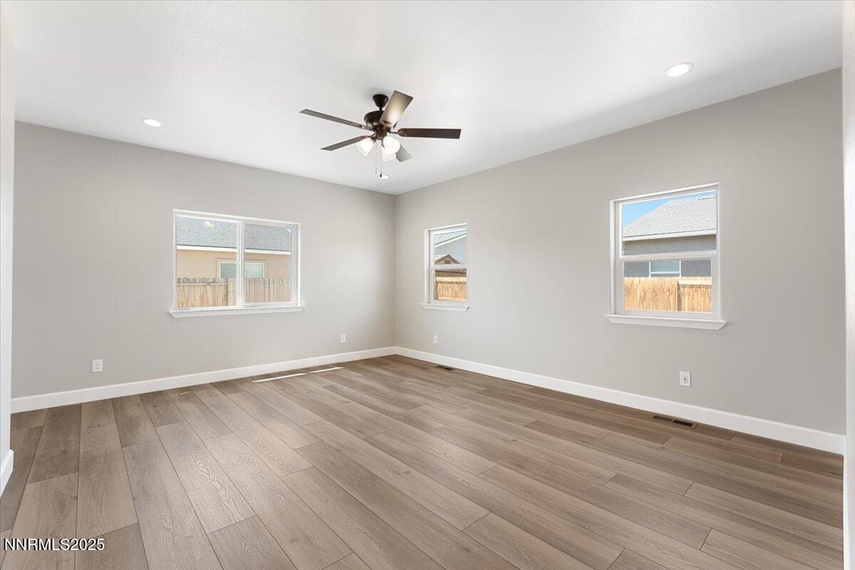 815 Great Basin Lane Fallon, NV 89406 - Photo 27 of 49 a view of an empty room with a window and wooden floor